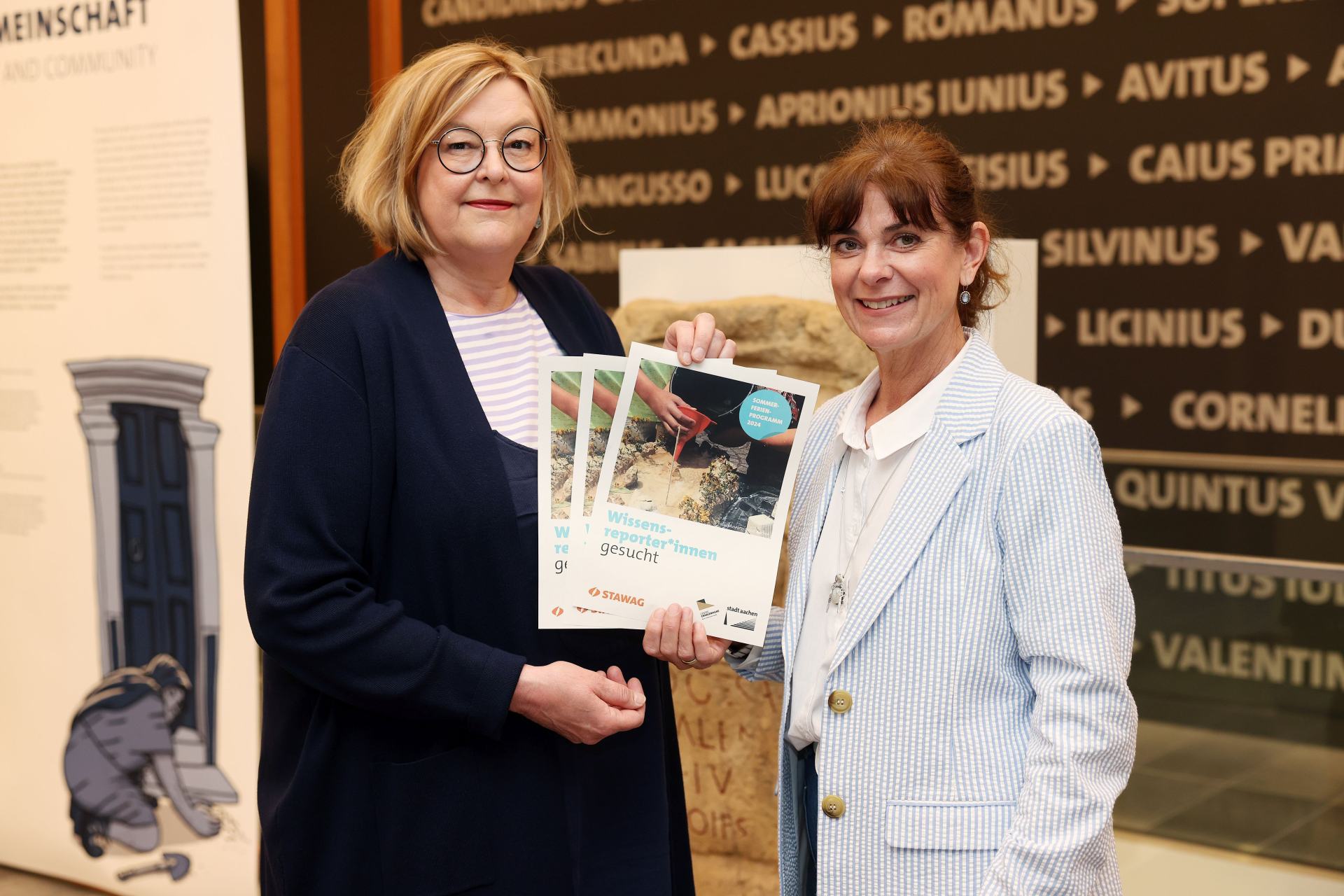 (v.l.n.r.) Pia vom Dorp, Leiterin des Museumsdienstes der Stadt Aachen, und Kirsten Haacke von der Stawag präsentieren die Sommerferienangebote der Route Charlemagne und des Ludwig Forums Aachen. Copyright © Stadt Aachen / Andreas Steindl