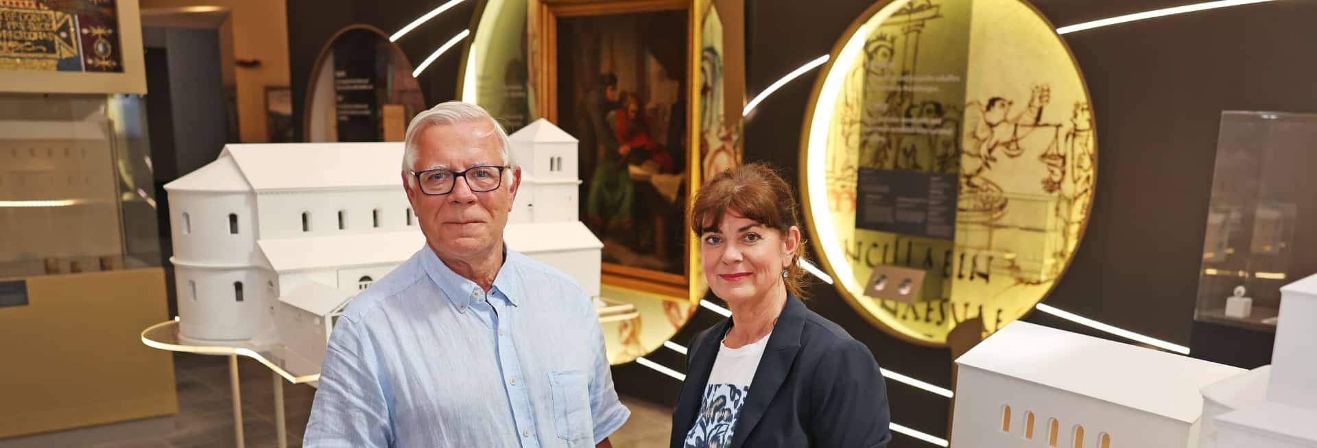 Udo Krieger vom Museumsdienst Aachen und Kirsten Haacke von der STAWAG präsentieren das neue Programm „Wissensreporter*innen 2026“ im Centre Charlemagne. Copyright © Stadt Aachen / Andreas Steindl